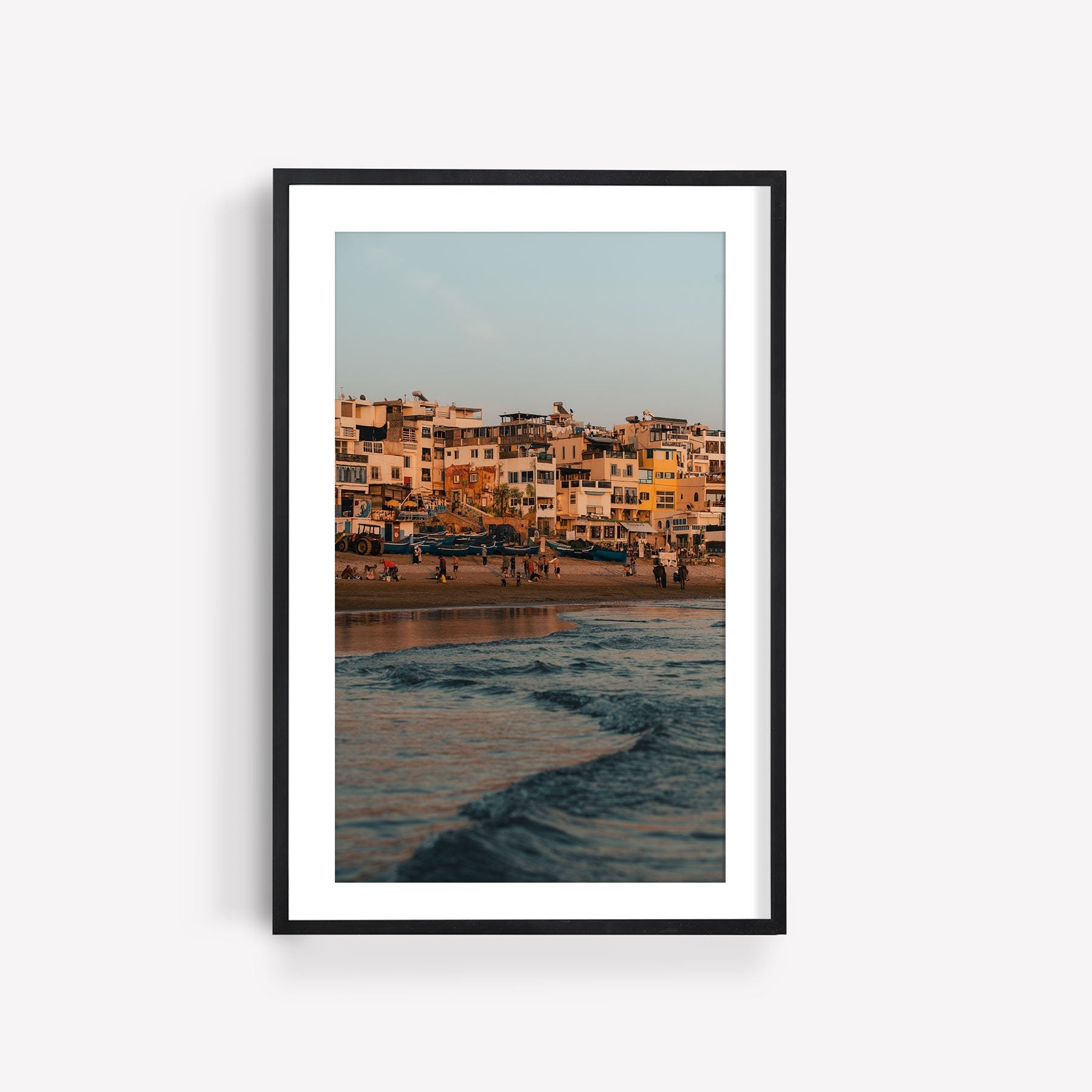 A framed photo titled Taghazout Wave, showcasing a sunset beach scene with waves and buildings in the background.