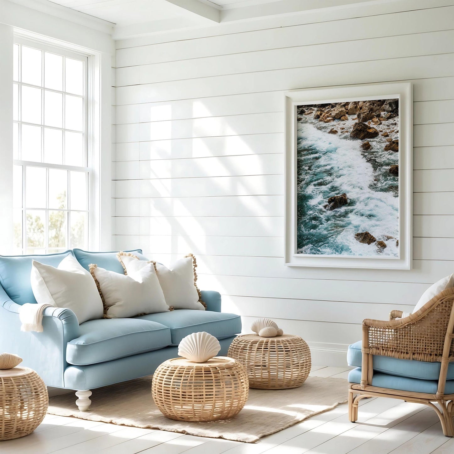 Bright coastal living room with Teal Tide sofa, rattan furniture, and ocean photo on white shiplap wall.