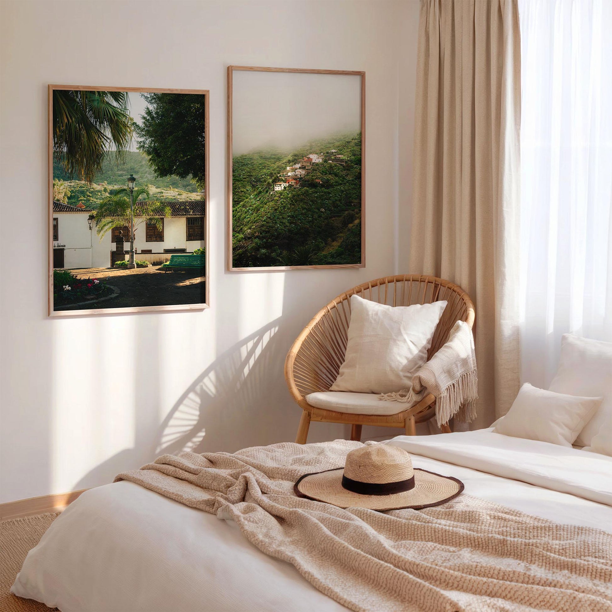 Sunlit bedroom with beige bedding, a straw hat, a rattan chair, and Tenerife Greenery - Set of 2 on the wall.