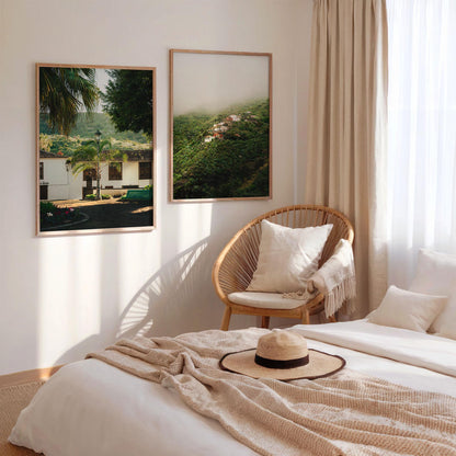 Sunlit bedroom with beige bedding, a straw hat, a rattan chair, and Tenerife Greenery - Set of 2 on the wall.