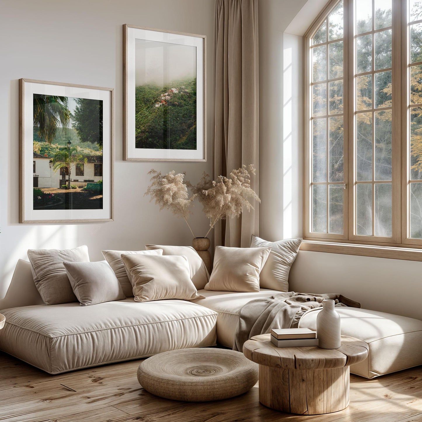 A sunlit living room with beige furniture, wood tables, large windows, and Tenerife Greenery - Set of 2 wall art.