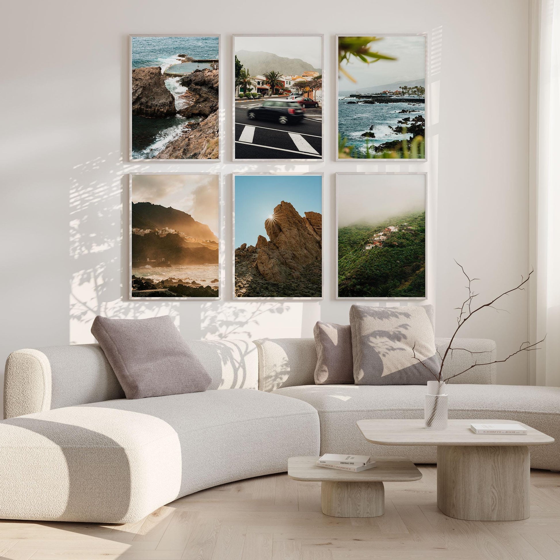 Modern living room with a curved sofa, minimalist table, and the Tenerife - Set of 6 landscape photos on the wall.
