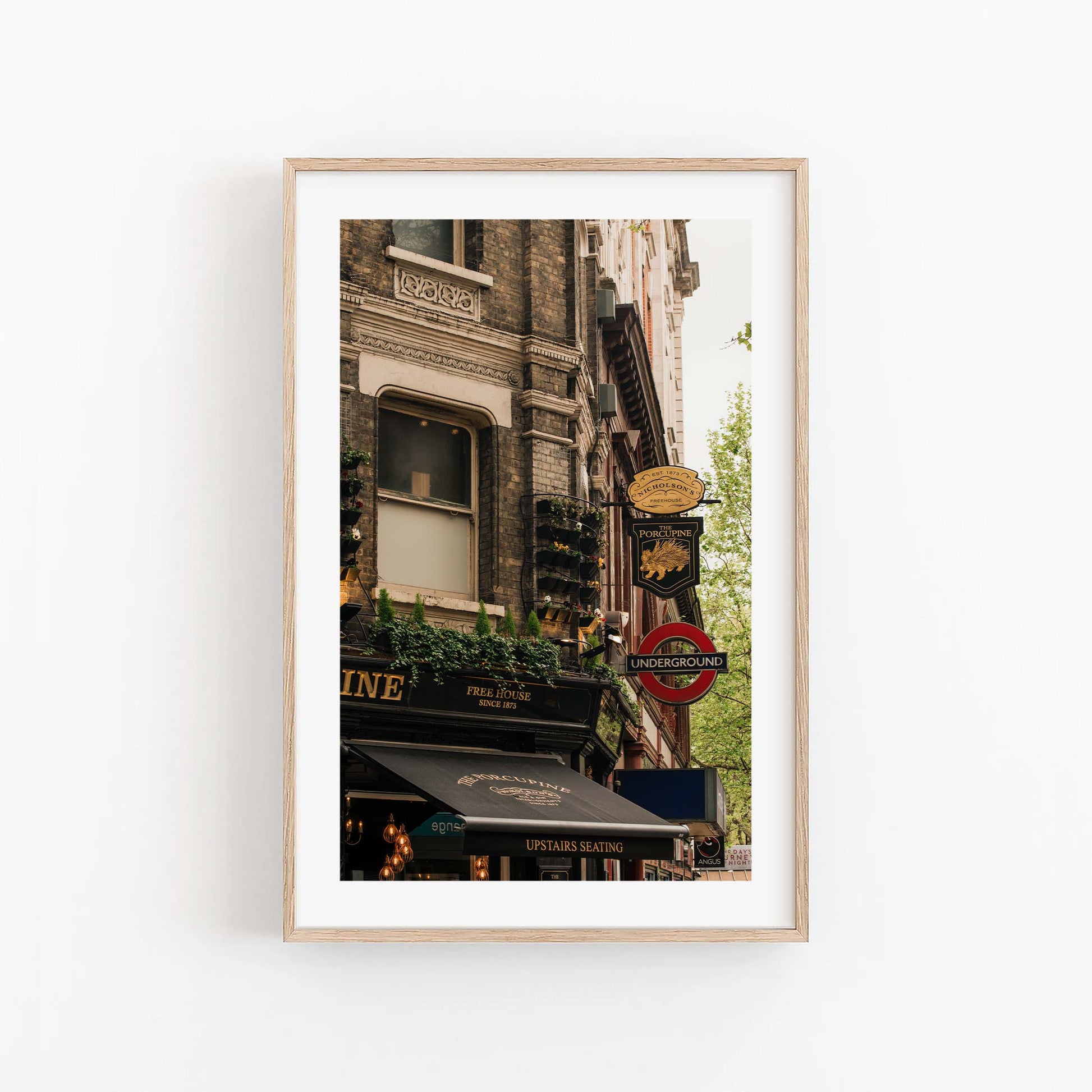 Framed photo of The Porcupine Pub with London Underground sign and historic buildings on a white wall.