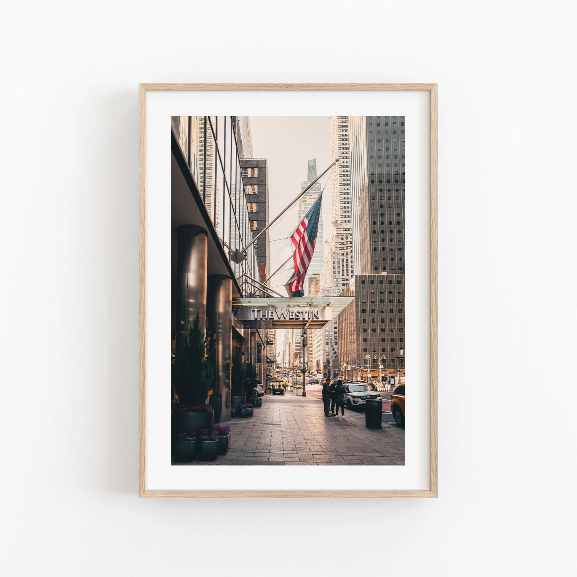 Framed city street photo with buildings, an American flag, and a The Westin sign.