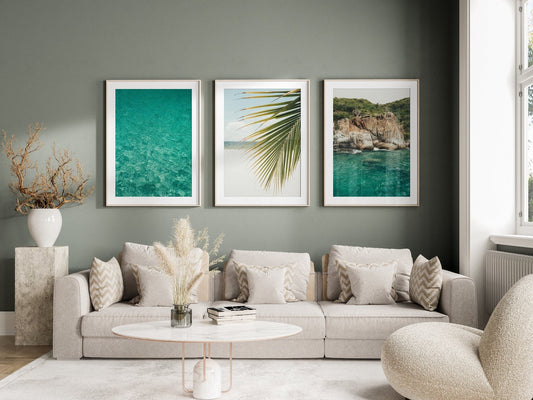 A modern living room with a beige sofa, Tropical Turquoise wall art set, and a round marble coffee table.