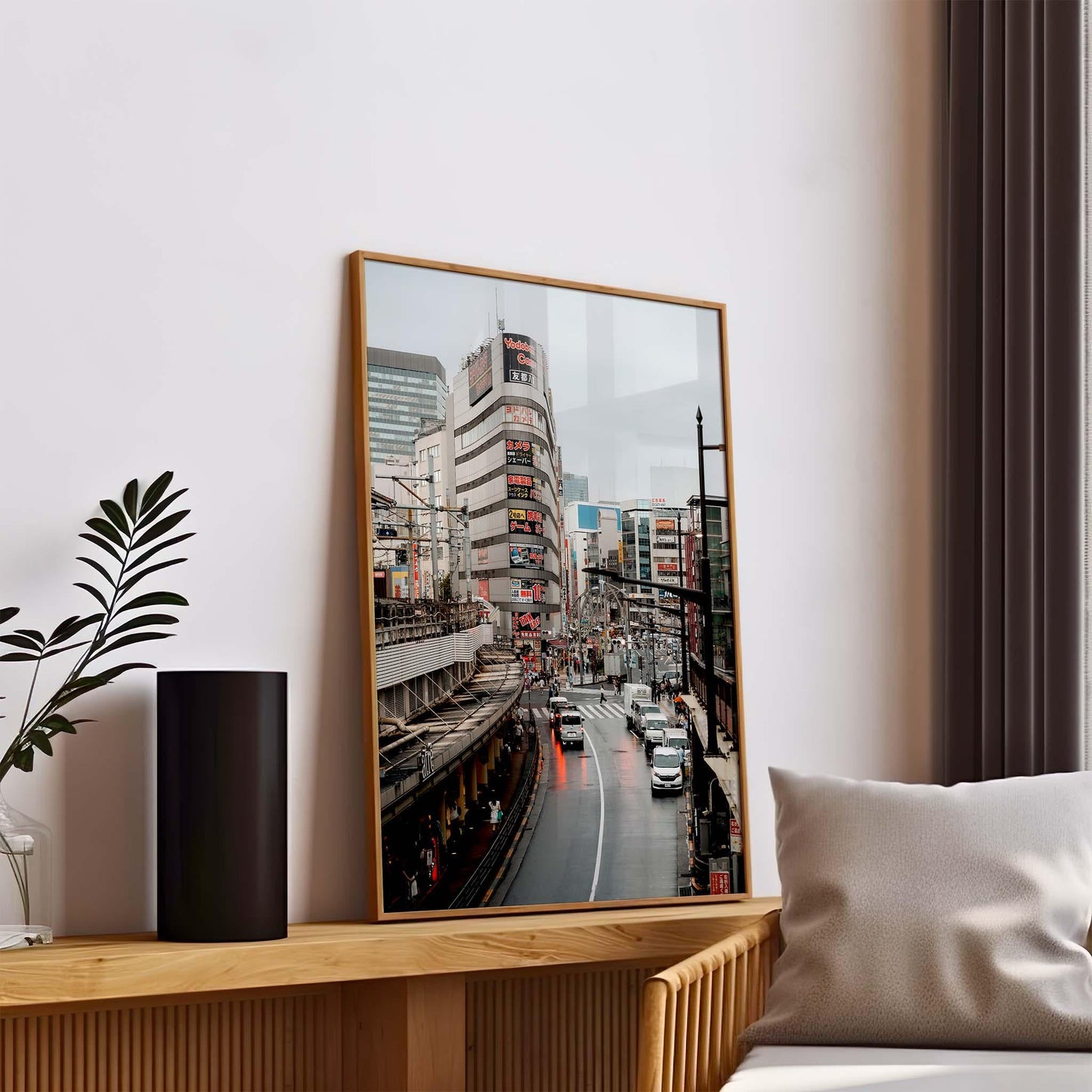 Ueno Cityscape photo on a wooden console, adds charm alongside a potted plant and pillow in a bright, modern room.