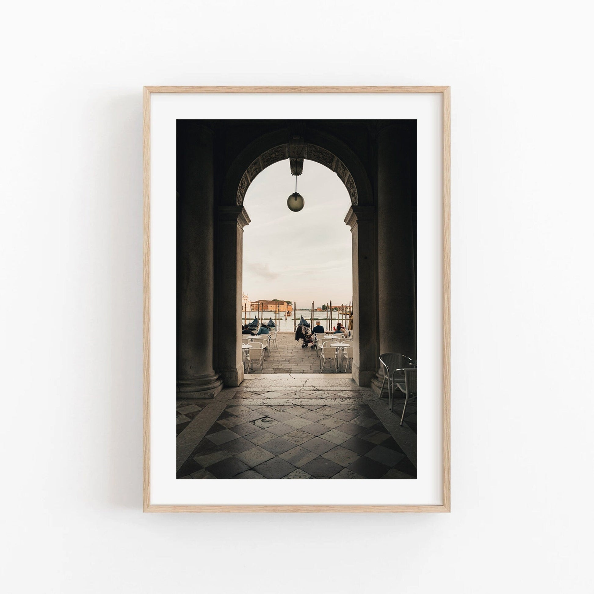 Framed Venice Arch photo features an archway, chairs, and a waterfront view.