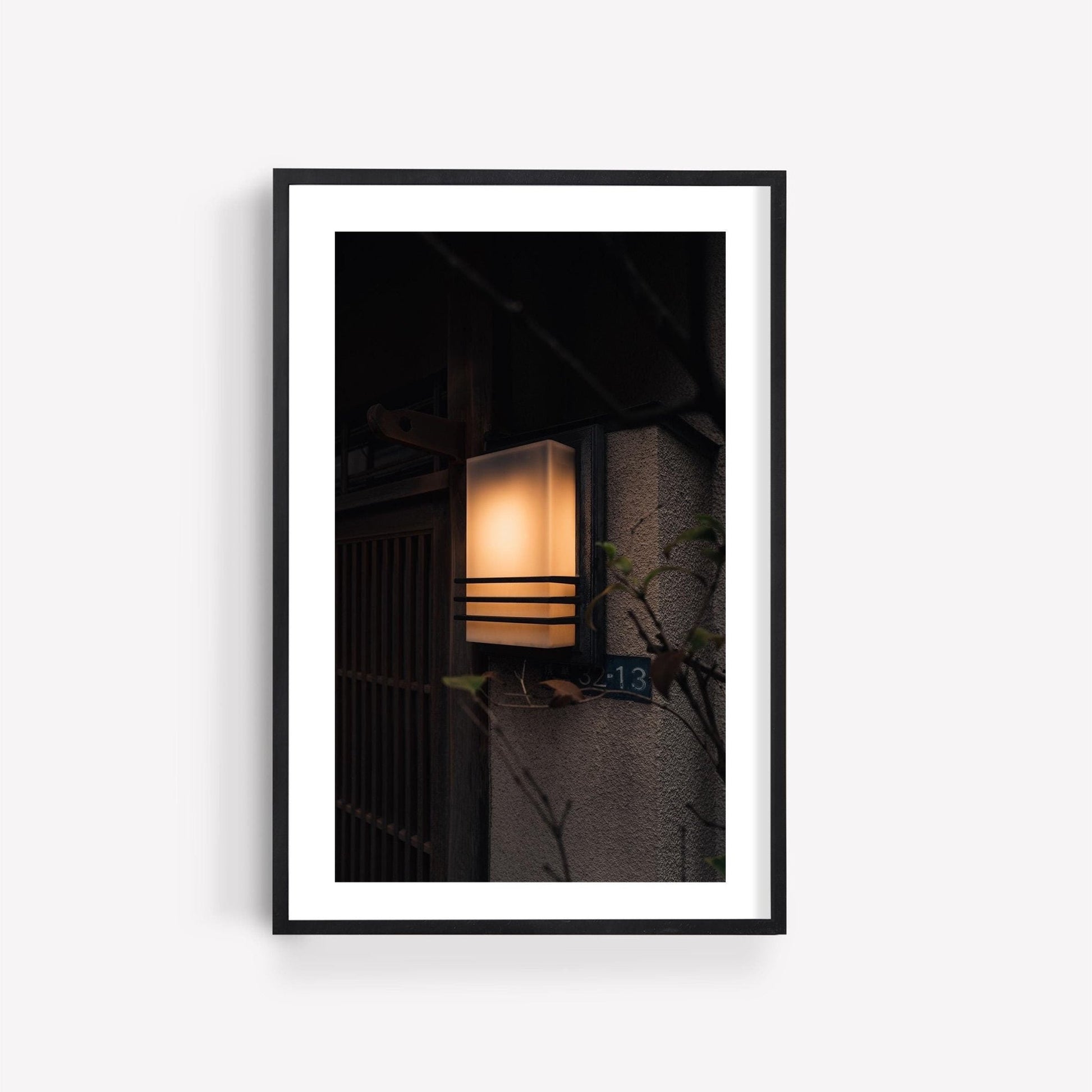 A framed photo of Zen Ambience, a lit wall lantern featuring horizontal lines, mounted on a dimly lit wall displaying the number 13.