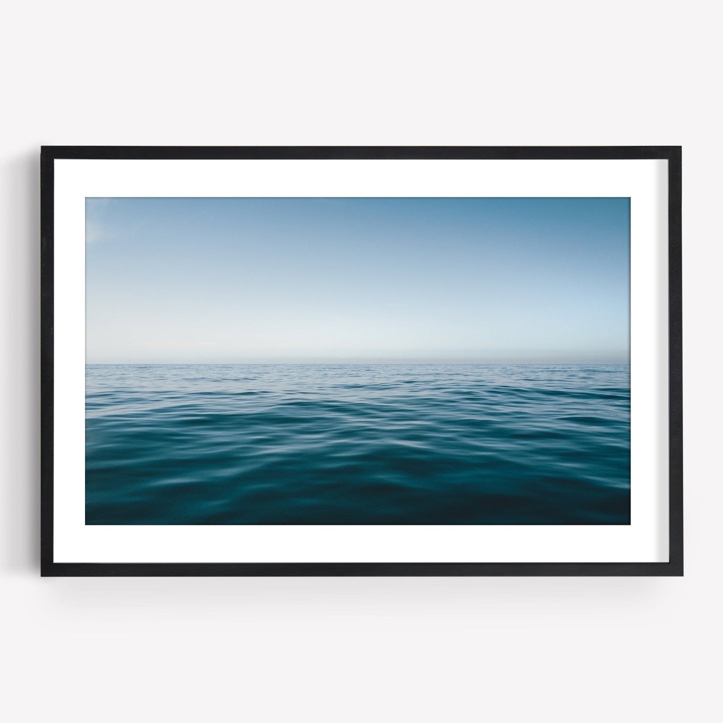 Framed Zen Ocean photo of a calm ocean under a clear blue sky, showcasing the horizon line.