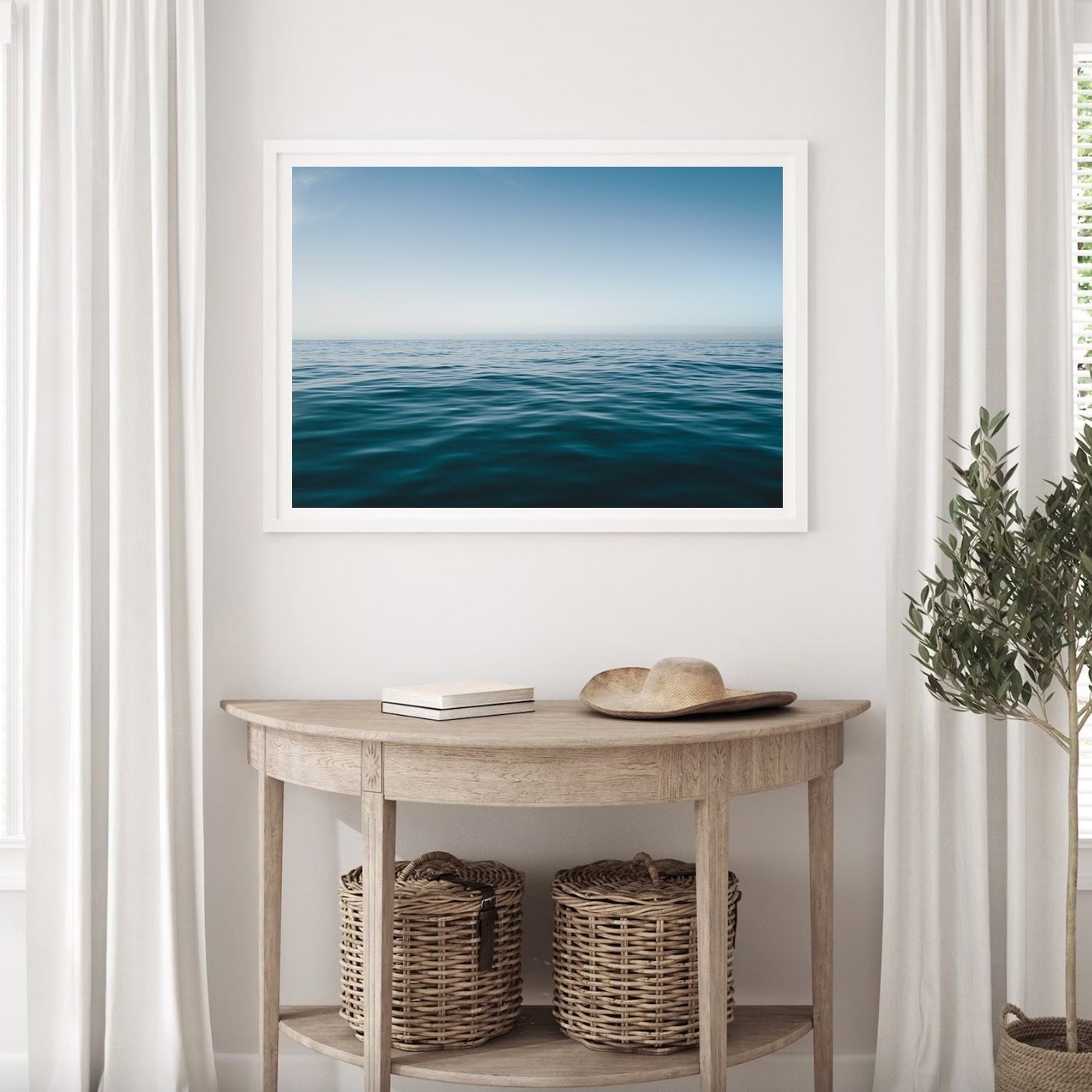 The Zen Ocean photo frames a wooden console with woven baskets and a potted plant, accented by white curtains.